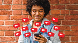 Girl holding phone with burst of red instagram "likes" coming out of the phone